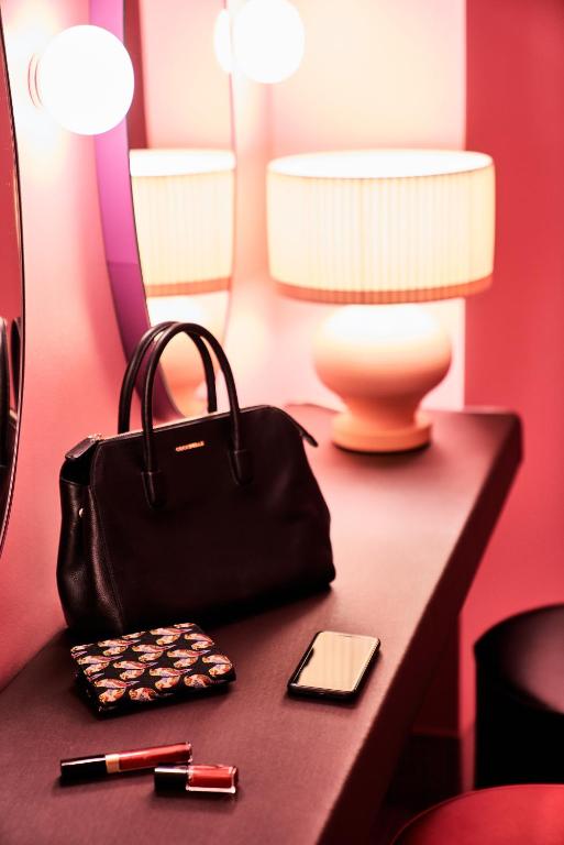 a black purse sitting on a table next to a lamp at SIDE, Hamburg, a Member of Design Hotels in Hamburg