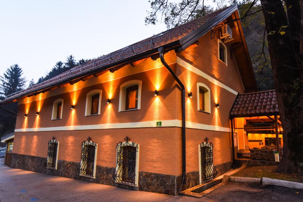 un bâtiment avec des lumières sur son côté dans l'établissement Gorska Reka Guesthouse, à Zreče