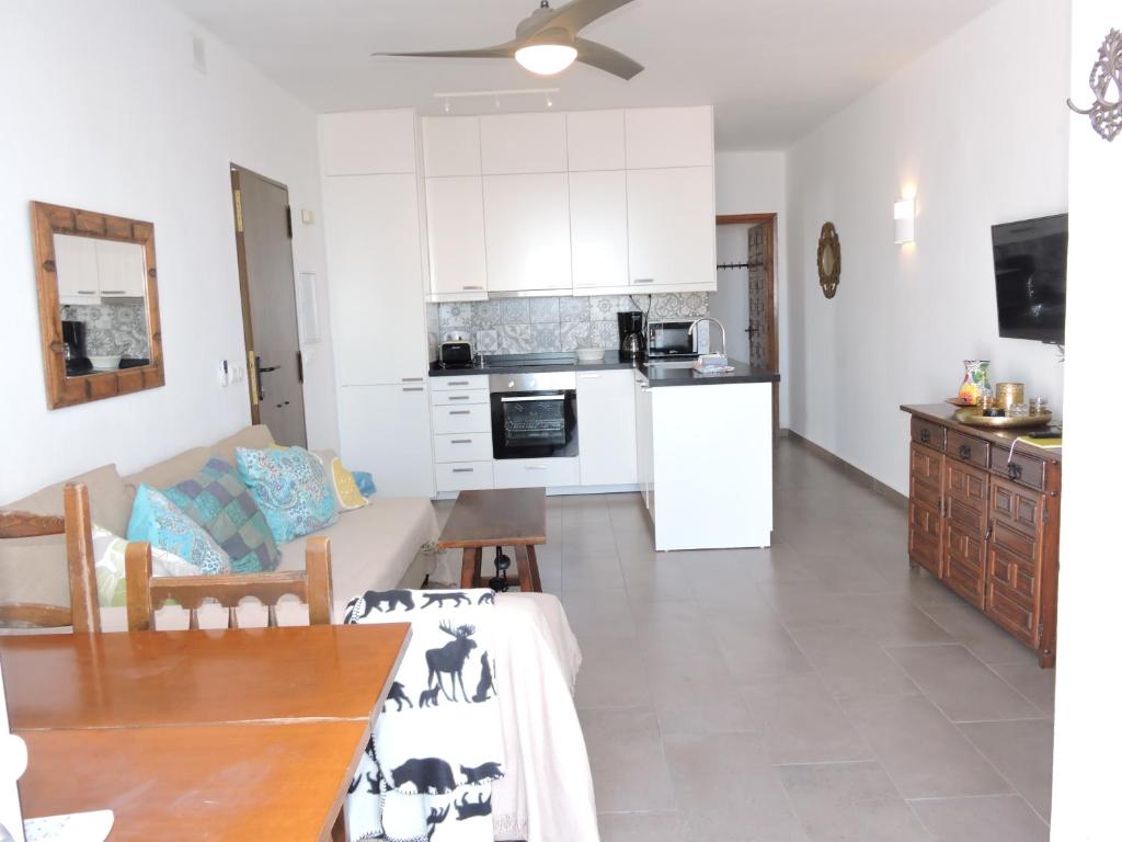 a kitchen and living room with a table and a refrigerator at Nerja Villas-Capistrano in Nerja
