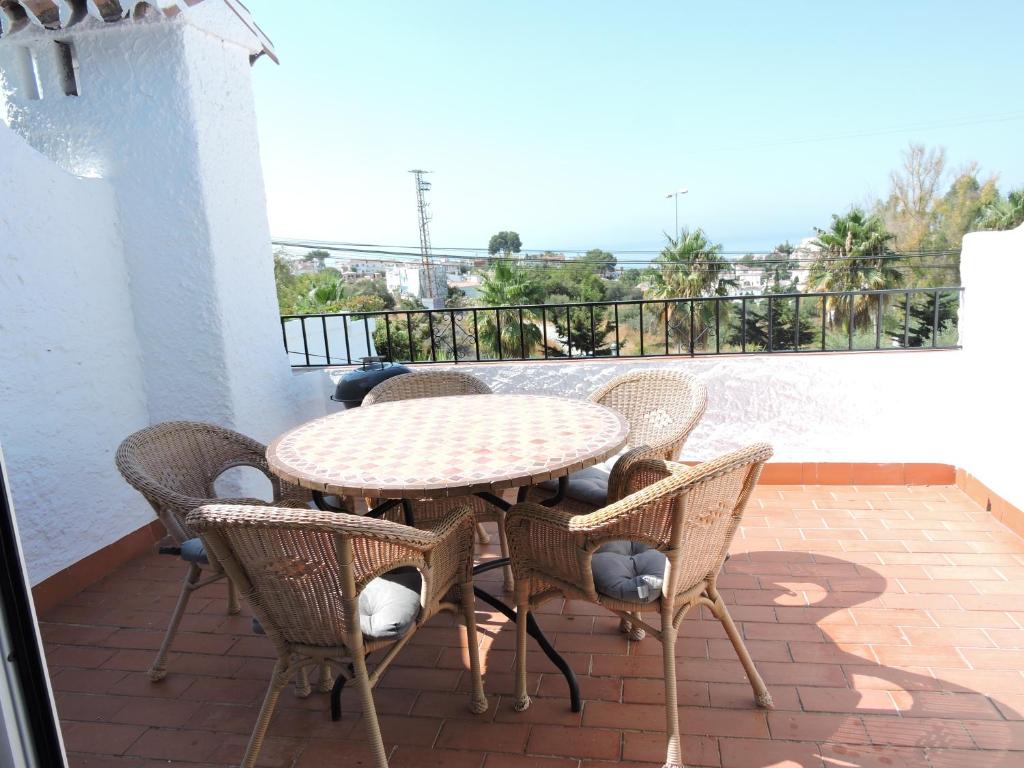 a patio with a table and chairs on a balcony at Nerja Villas-Capistrano in Nerja