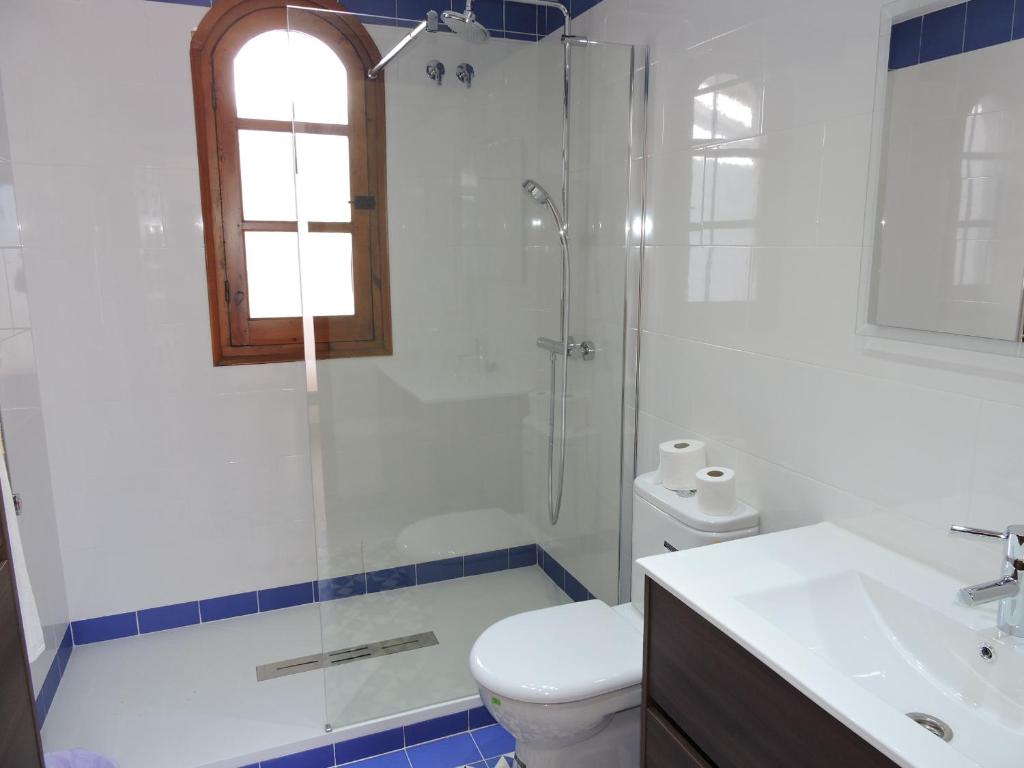 a bathroom with a shower and a toilet and a sink at Nerja Villas-Capistrano in Nerja
