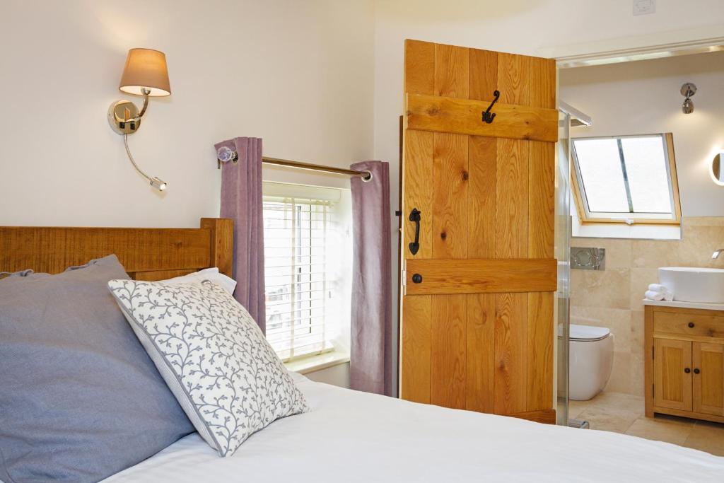 a bedroom with a bed and a sink and a window at Unit 1 Dove Farm Barns in Stoke on Trent