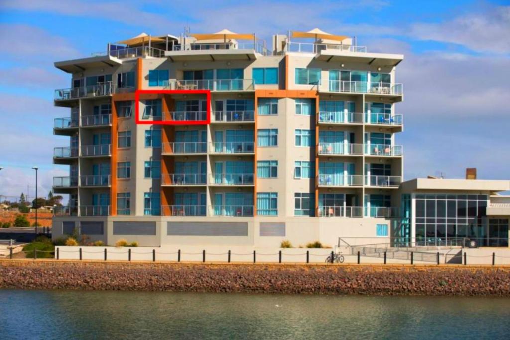 a large building next to a body of water at Wallaroo Marina Luxury Apartment in Wallaroo