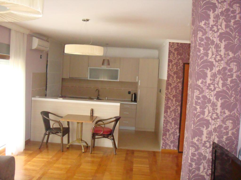 a kitchen and dining room with a table and chairs at Apartments Orfej in Sveti Stefan