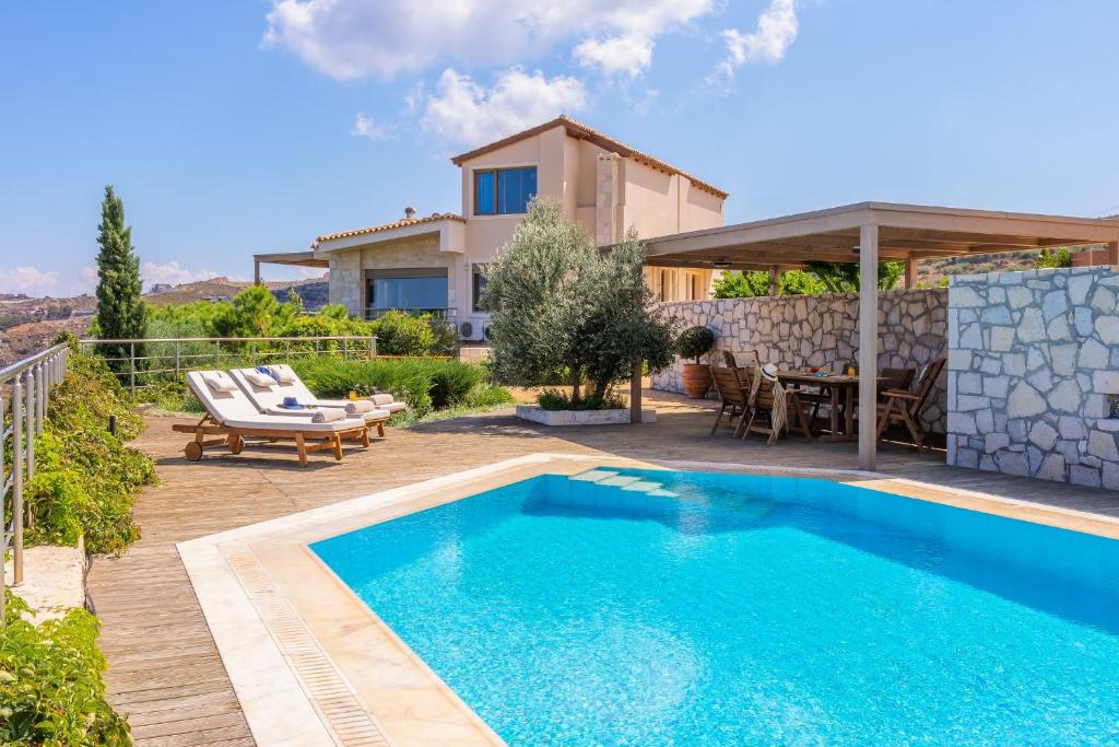 eine Villa mit einem Pool und einem Haus in der Unterkunft Villa Hara in Agia Pelagia