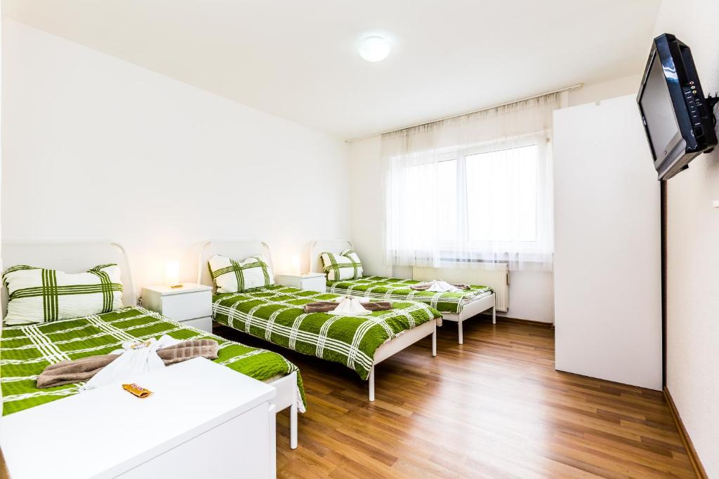 ケルンにあるWorkers Apartment am Wiener Platzのベッド3台、薄型テレビが備わる客室です。