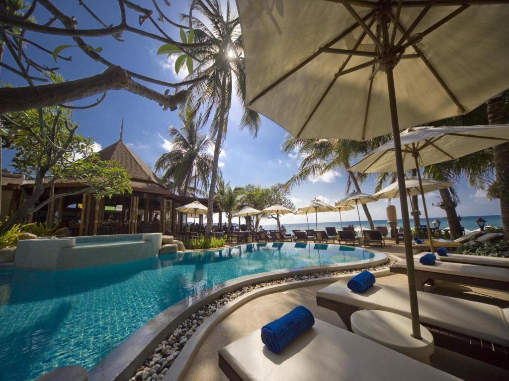 - une piscine avec des chaises et des parasols dans un complexe dans l'établissement Thai House Beach Resort, à Lamai