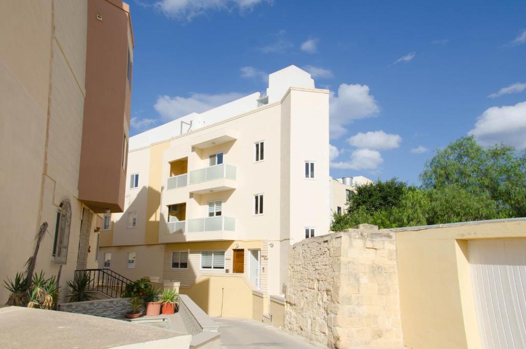 un condominio bianco con un muro in pietra di Lorenza Letting Maisonette a Marsaxlokk