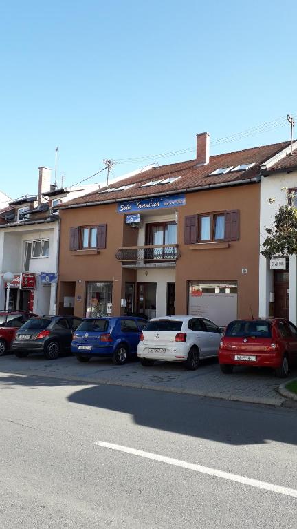 un gruppo di auto parcheggiate di fronte a un edificio di Guesthouse Ivancica a Našice