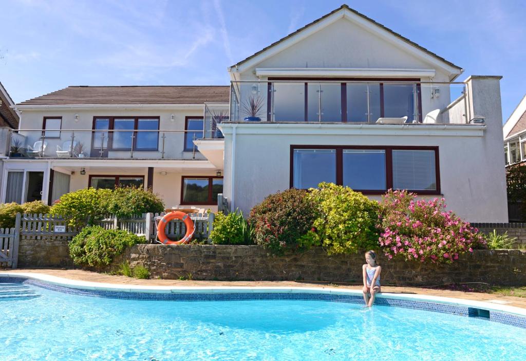 uma mulher parada numa piscina em frente a uma casa em Fairways em Eastbourne