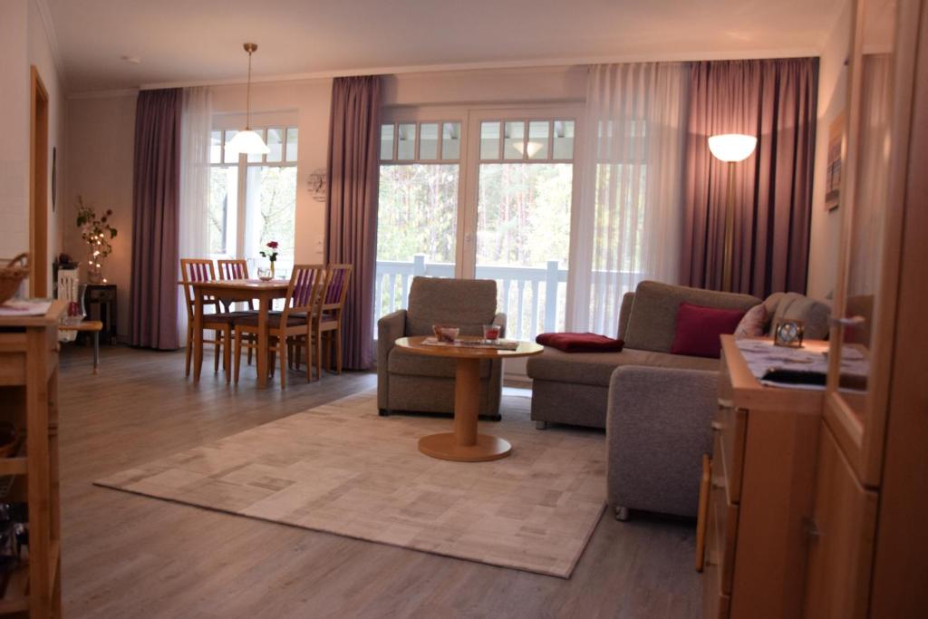 ein Wohnzimmer mit einem Sofa und einem Tisch in der Unterkunft Dünenpark in Binz für Eltern und Kind in Binz