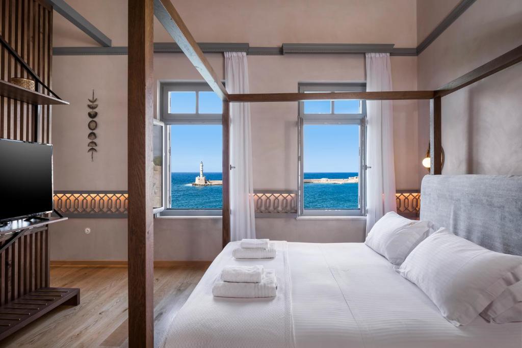 sypialnia z łóżkiem i widokiem na ocean w obiekcie Scala de Faro w Chanii
