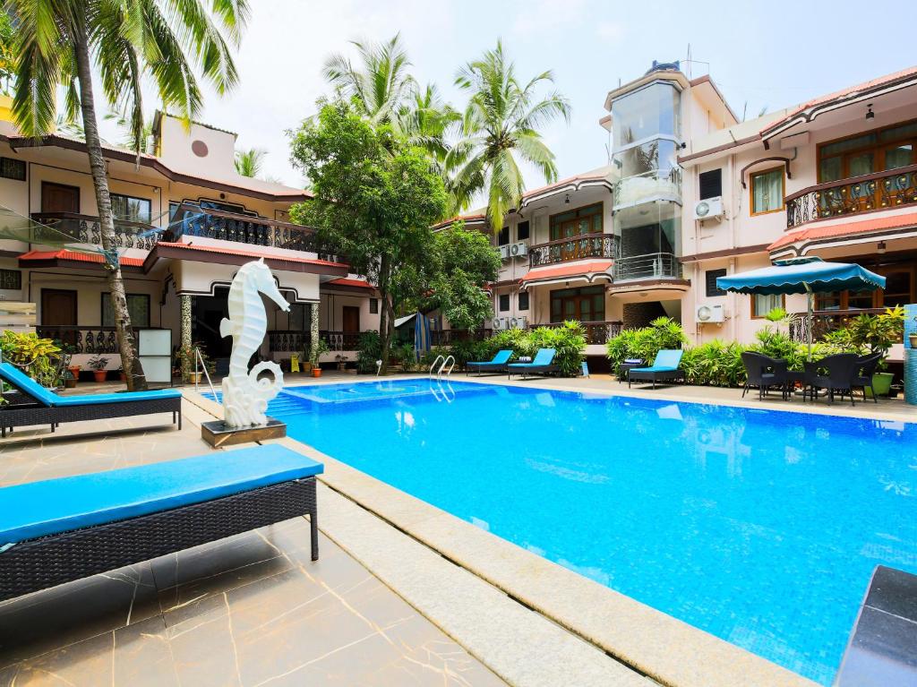 uma piscina num resort com uma estátua no meio em Sea View Resort em Patnem