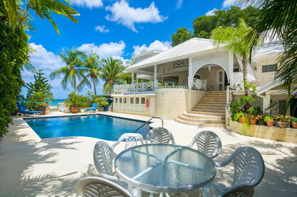 a house with a pool and a table and chairs at Tantalus in Bridgetown