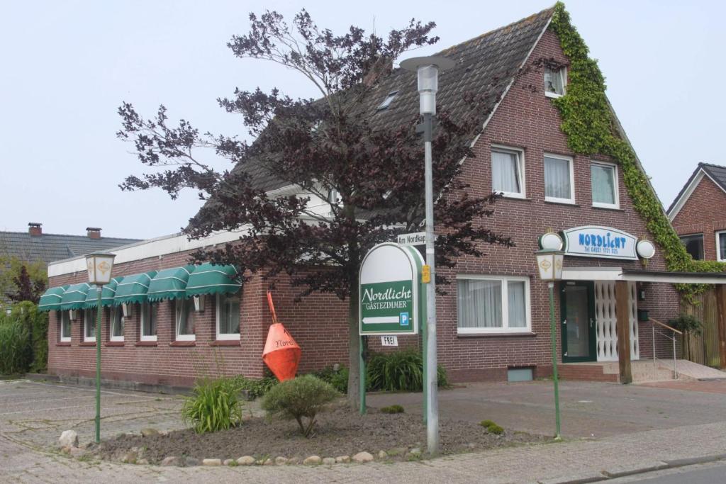 a building with a sign in front of it at Pension Nordlicht in Norddeich