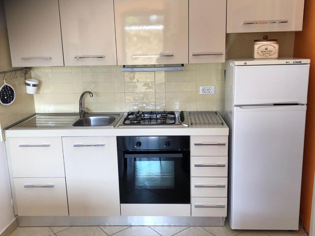 a white kitchen with a stove and a sink at Cà Suma in Borgio Verezzi