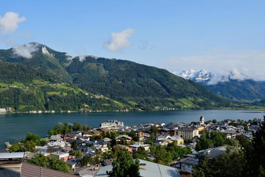 a town on the shore of a lake with mountains at Haus Altenberger in Zell am See