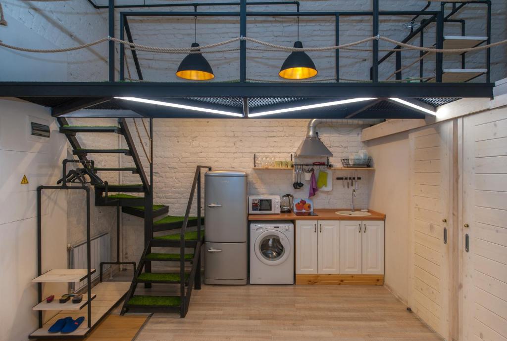 a kitchen with a staircase and a washer and dryer at Kolman Apart in Saint Petersburg