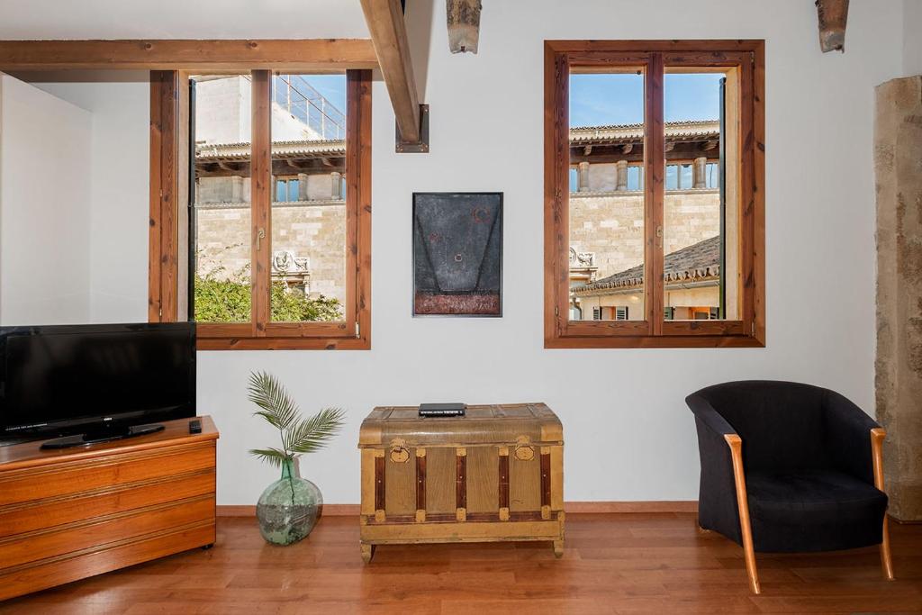 a living room with a tv and two windows at Ramón Llull House in Palma de Mallorca