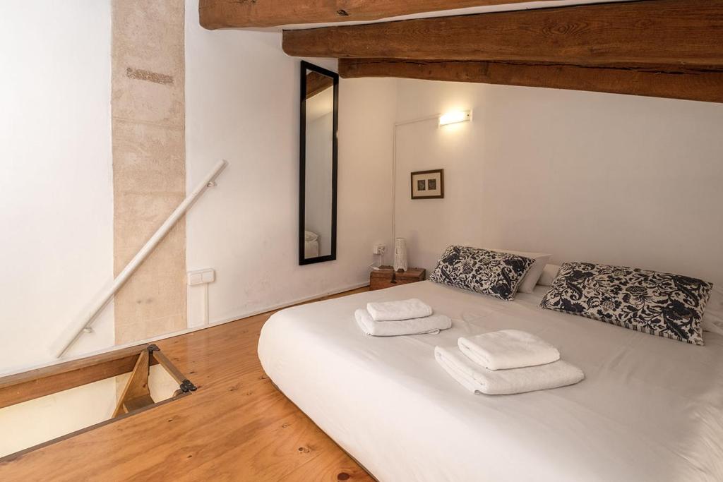 a white bed with two towels on it in a room at Ramón Llull House in Palma de Mallorca