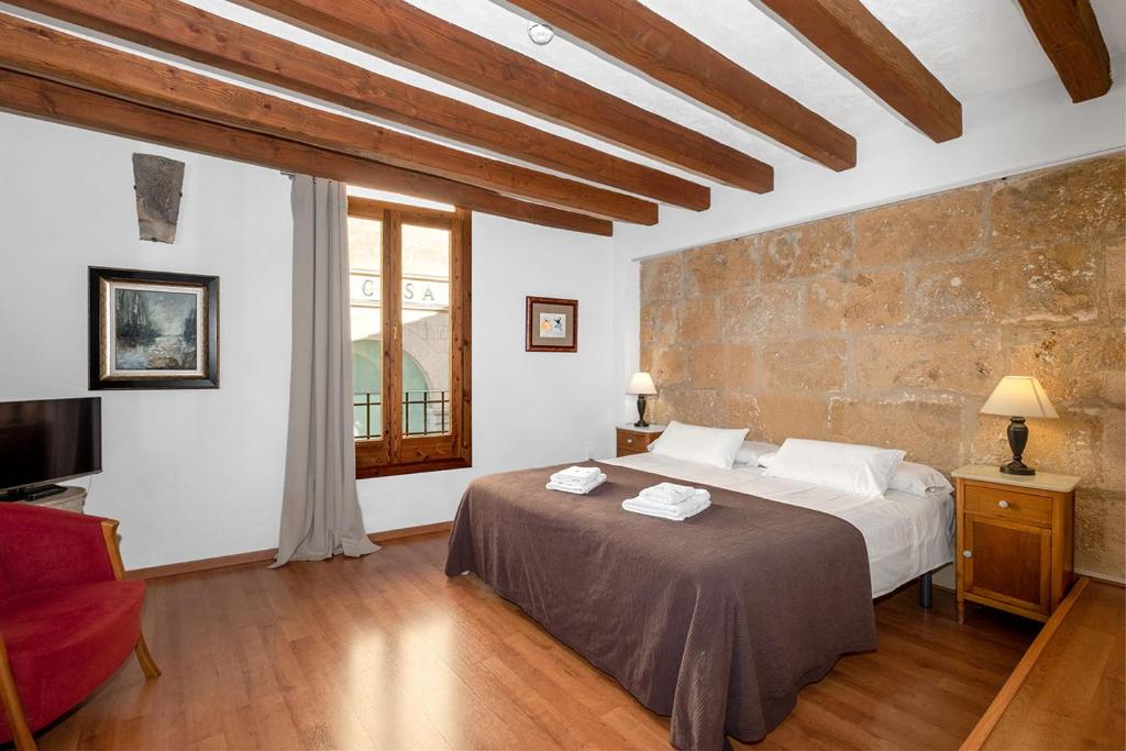 a bedroom with a large bed and a brick wall at Ramón Llull House in Palma de Mallorca