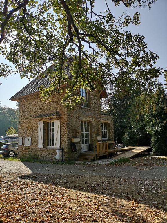 une maison en pierre avec un banc devant elle dans l'établissement Camping des Bondons, à La Ferté-sous-Jouarre