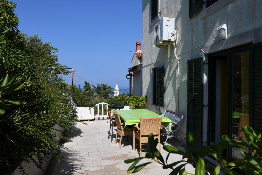 einen grünen Tisch und Stühle auf einer Terrasse in der Unterkunft Apartment with terrace and sea view in Mali Lošinj