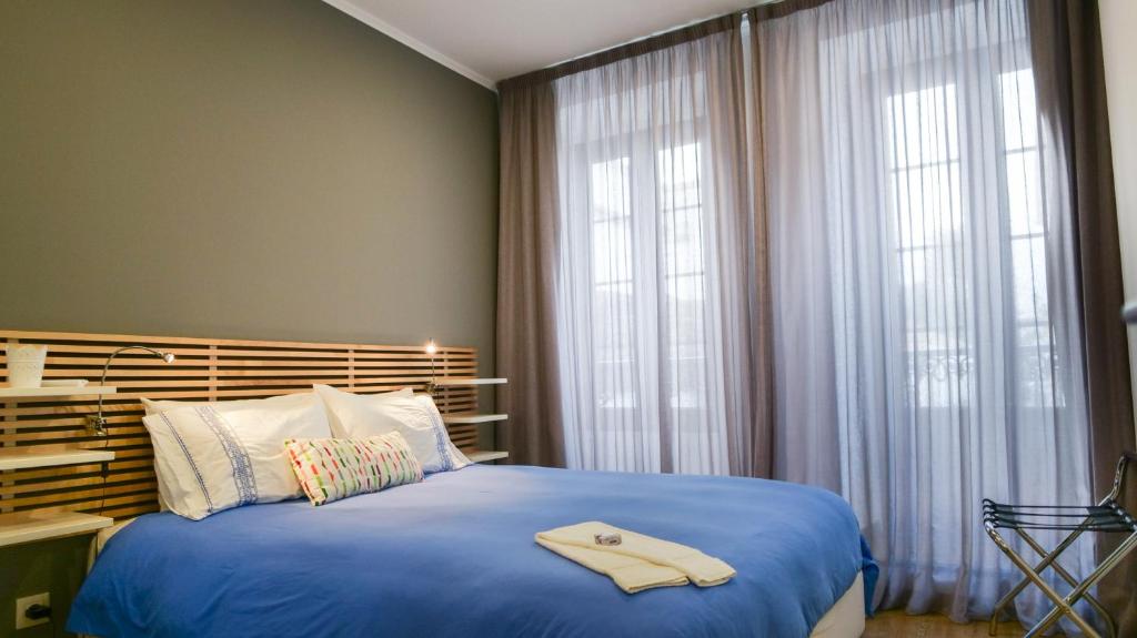 Un dormitorio con una cama azul con una toalla. en Cílio House - Duplex en Ponta Delgada