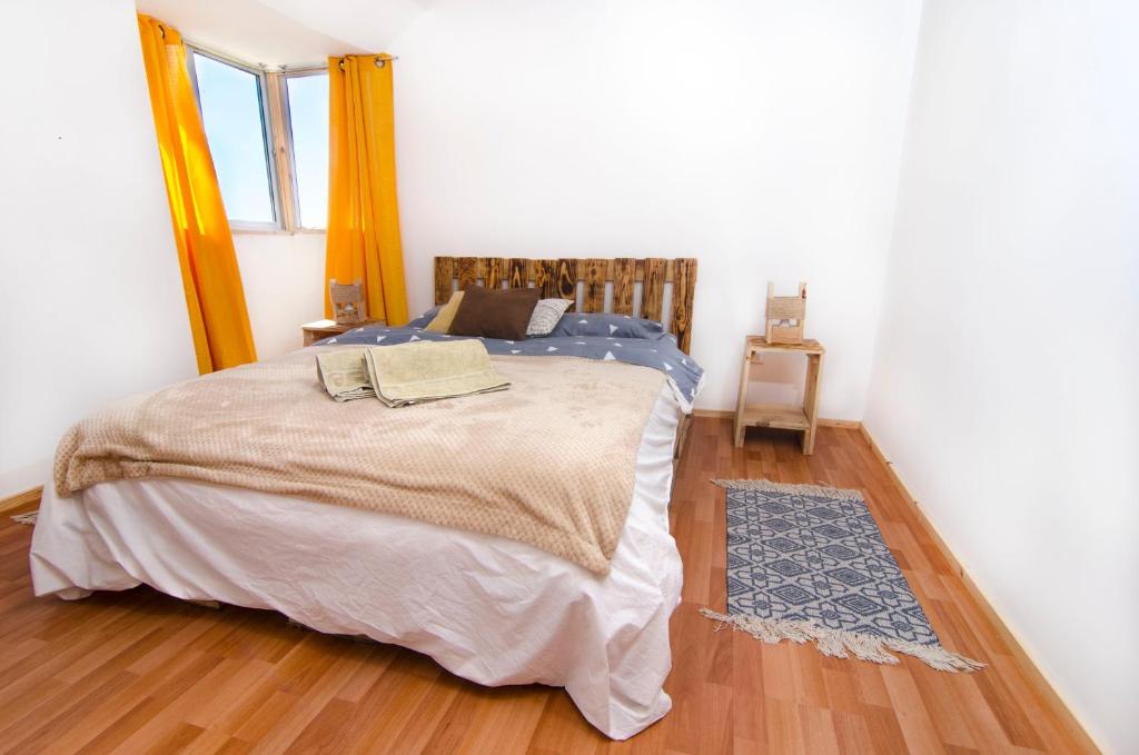 1 dormitorio con 1 cama y suelo de madera en Mi Paz, en Valparaíso