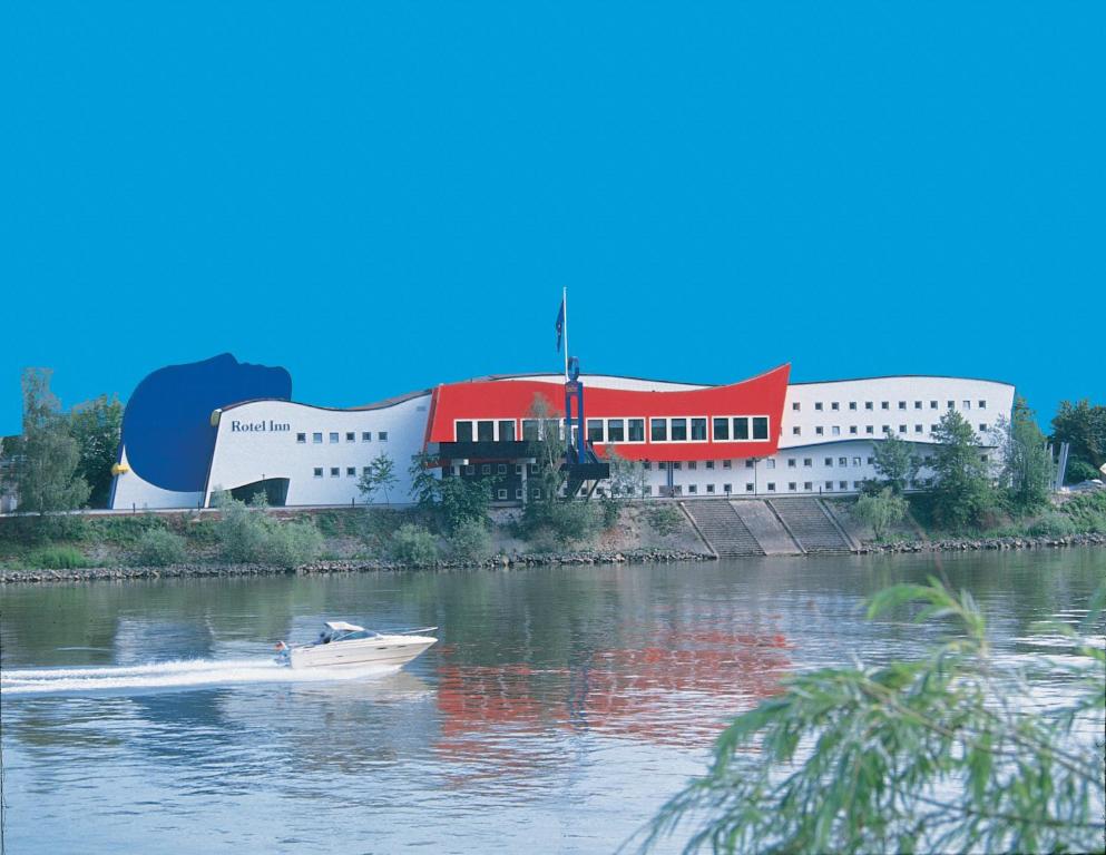 een boot in het water voor een gebouw bij Rotel Inn in Passau