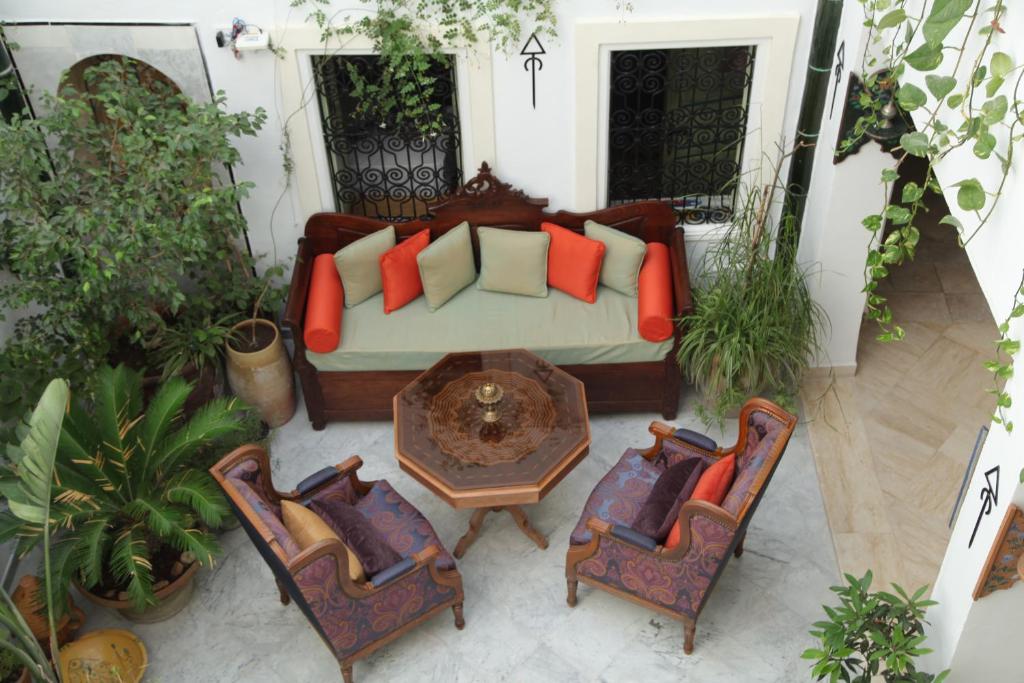 a living room with a couch and a table and chairs at El Patio Courtyard House in Tunis