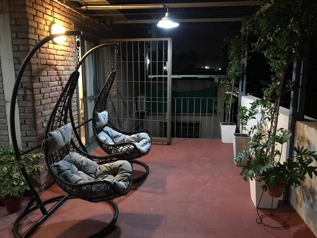 ein paar Stühle, die nachts auf einer Terrasse sitzen in der Unterkunft Alquiler temporario Mendoza in Mendoza