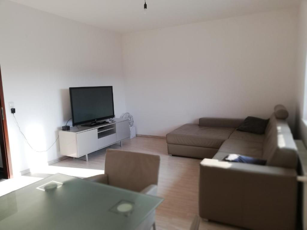 a living room with a couch and a tv at Modernes 2-Zimmer-Apartment nahe Graz in Gratkorn