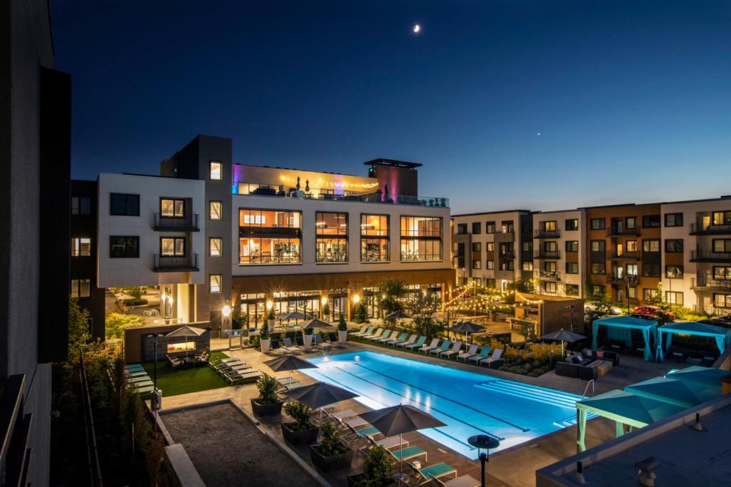 a large building with a swimming pool at night at Global Luxury Suites in Menlo Park in Menlo Park
