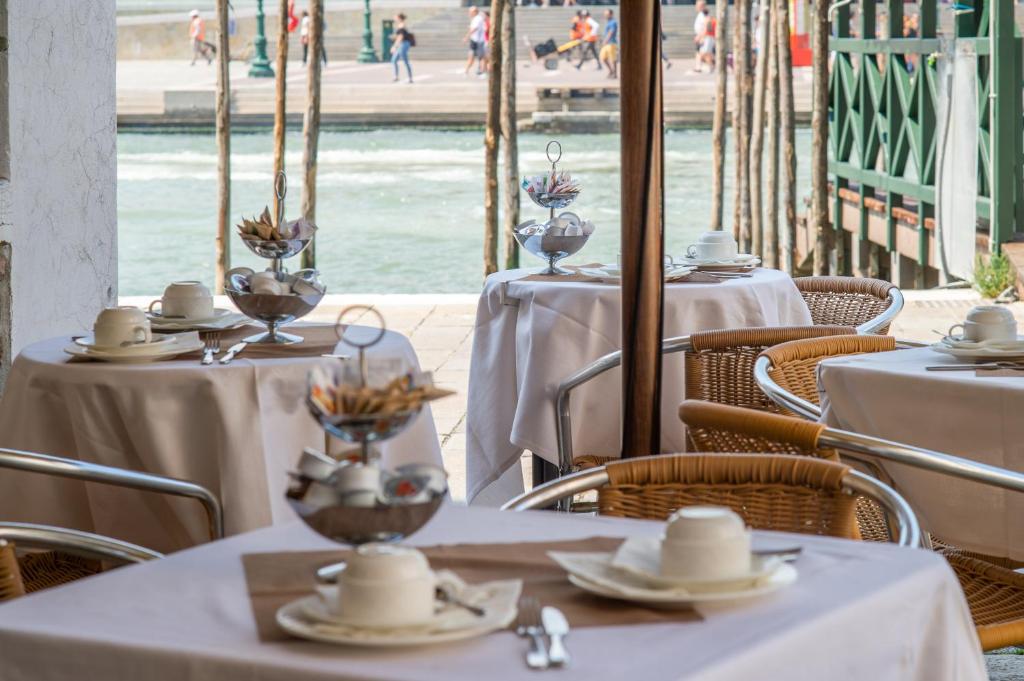 a restaurant with tables and chairs with white table cloth at Hotel Antiche Figure in Venice