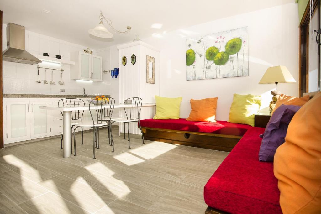 a living room with a table and a red couch at Los Topes in Puerto del Carmen