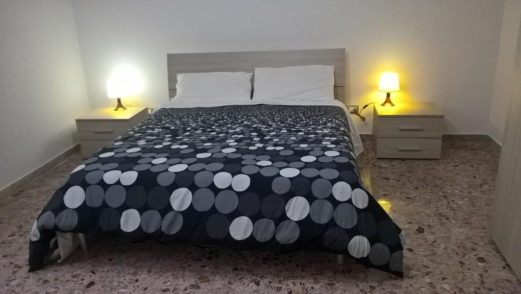 a bedroom with a bed with a black and white comforter at Ercole in riposo in Caserta