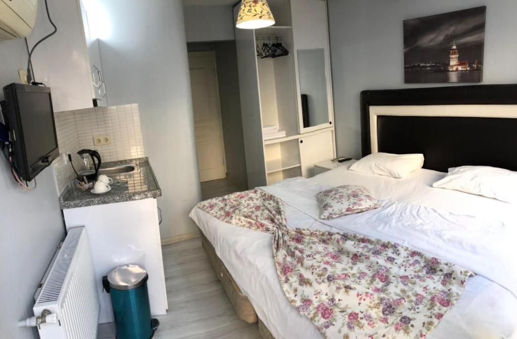 イスタンブールにあるTaksim Square Seven Residenceのベッドルーム1室(花の毛布付きのベッド1台付)