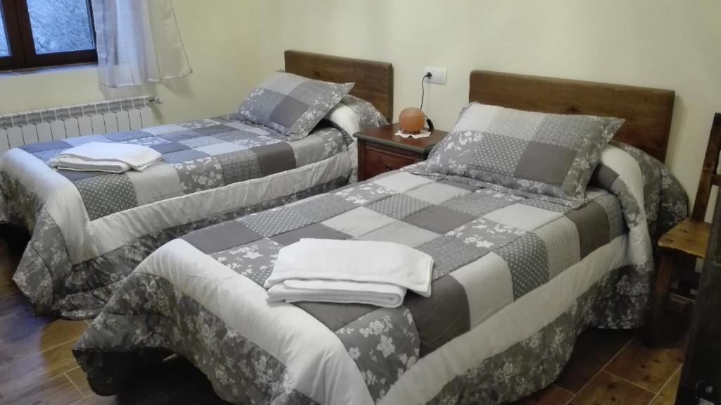 two beds sitting next to each other in a room at Entre las Piedras y musgo in Muñopepe
