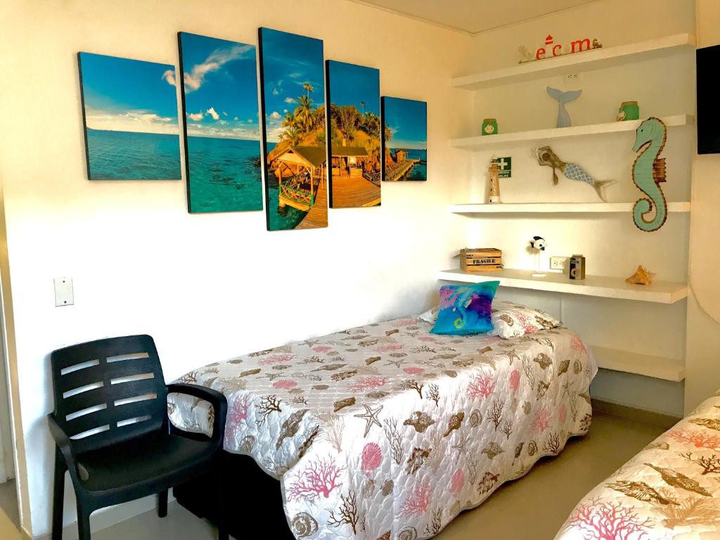 a bedroom with a bed and a chair at Apto en SAI a metros de la playa - DASH Vacaciones in San Andrés