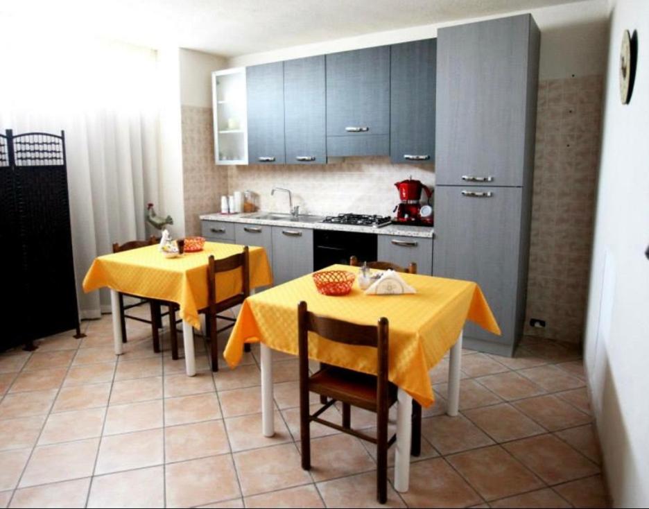 uma cozinha com duas mesas e uma toalha de mesa amarela em B&B IL GALLETTO R. em Gangi