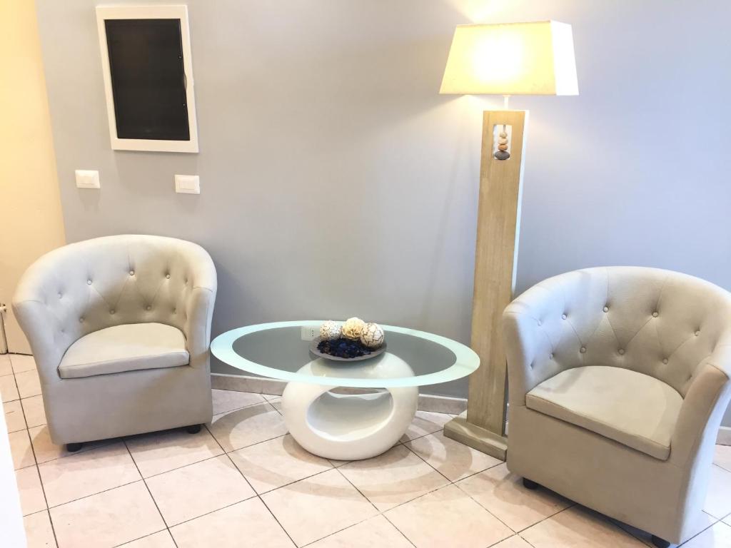 duas cadeiras e uma mesa e um candeeiro num quarto em Bakirooms em Roma
