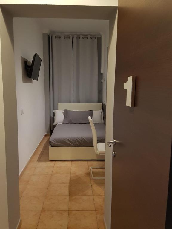 sypialnia z łóżkiem i drzwiami prowadzącymi do pokoju w obiekcie Bakirooms w Rzymie