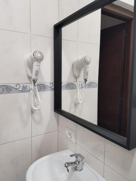 W łazience znajduje się lustro i umywalka. w obiekcie Bakirooms w Rzymie