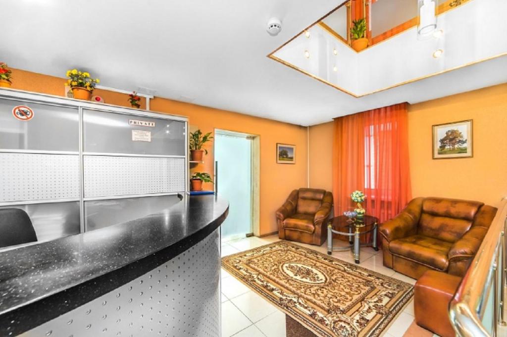 a kitchen with a sink and two chairs in a room at Hotel Filton in Tyumen