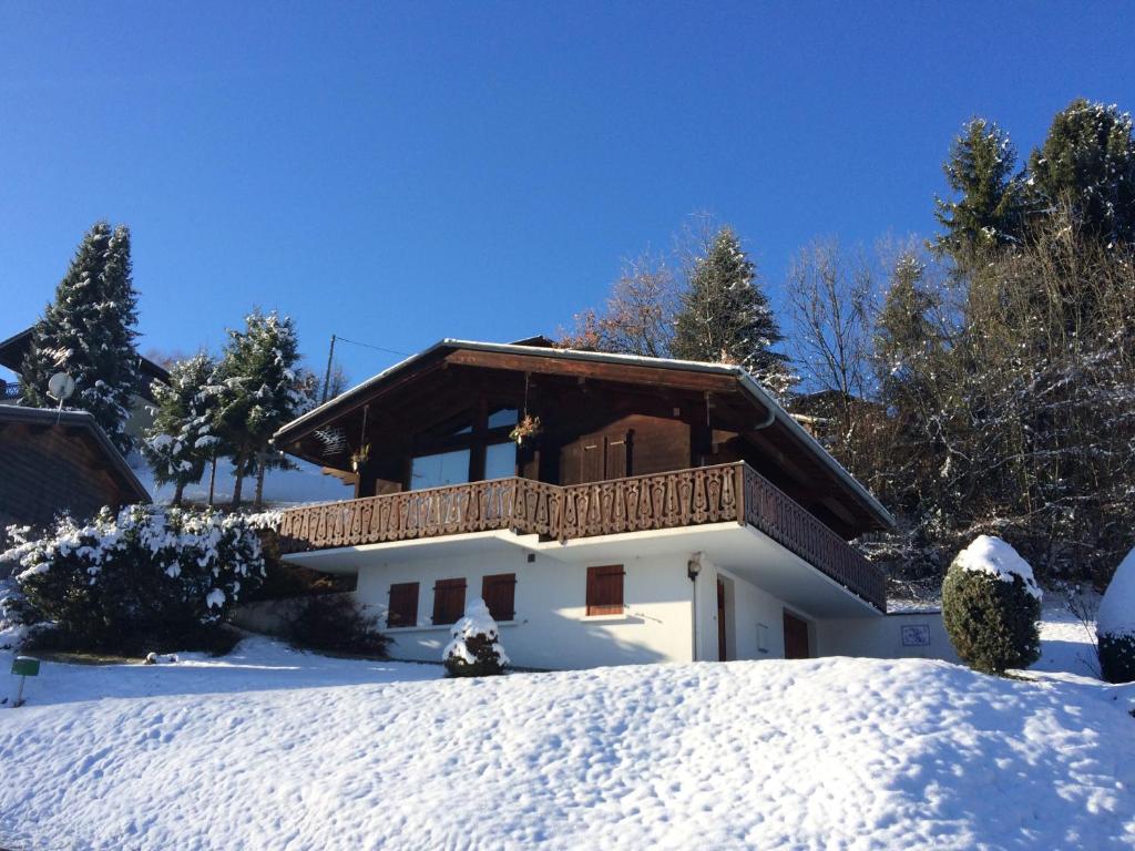 uma casa com varanda na neve em Les Oiseaux Bleus em Morillon