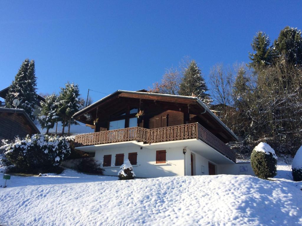 a house with a balcony in the snow at Les Oiseaux Bleus in Morillon