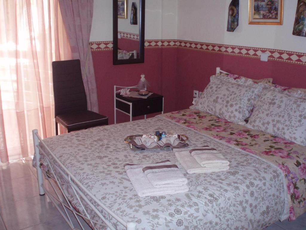 um quarto com uma cama com toalhas e uma cadeira em 3 Brothers - Διαμέρισμα στο κέντρο των Τρικάλων em Tríkala