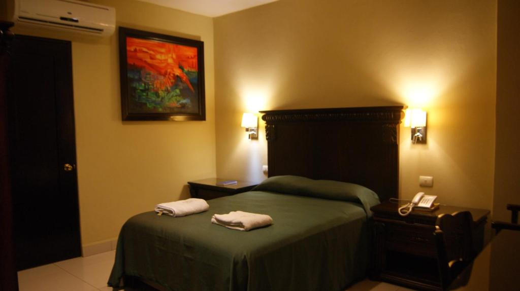 a bedroom with a bed with two towels on it at Hotel San Francisco in Salina Cruz