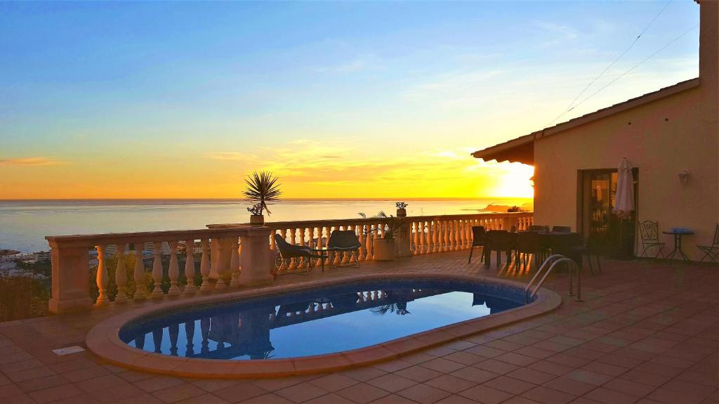 einen Pool auf einem Balkon mit Blick auf den Sonnenuntergang in der Unterkunft Ashram Villa Sunshine in Sitges